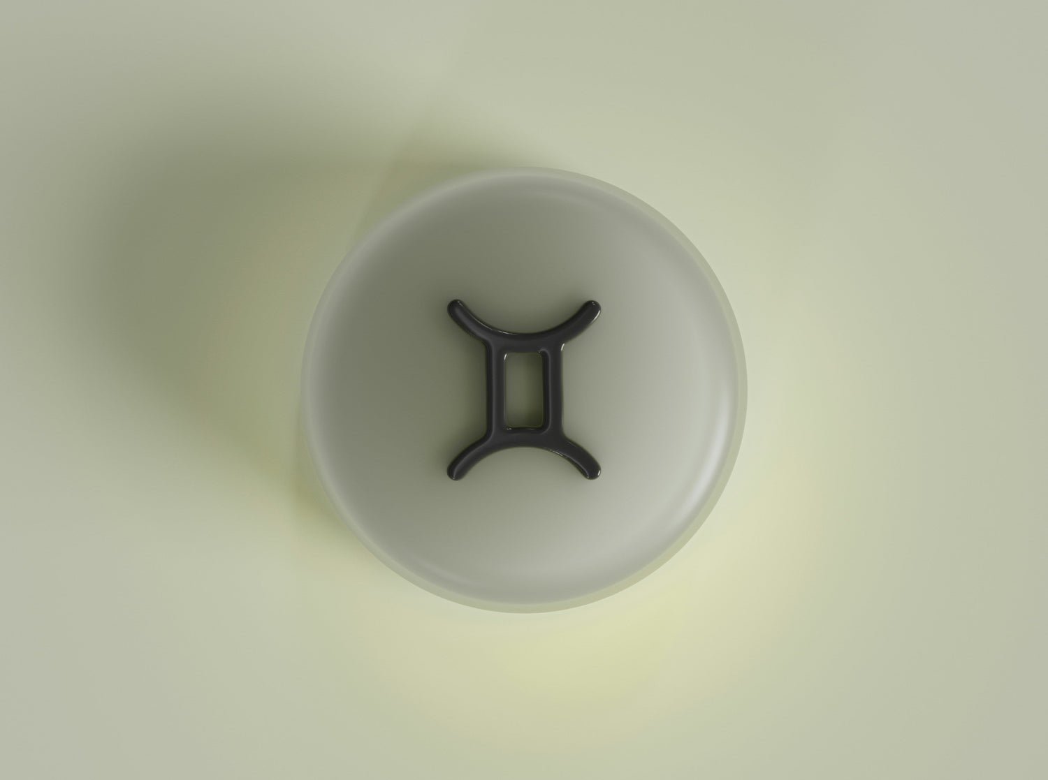 Gemini zodiac symbol embossed on a round pale green button centered on a soft green background