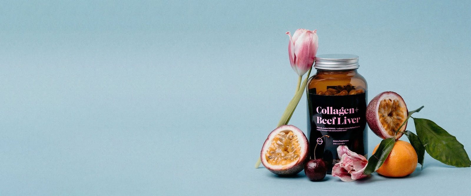 Front view of Collagen and Beef Liver amber jar with capsules beside passionfruit and tangerine on light blue background
